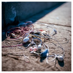 Close up of a tangled pile of colorful satin ribbons with metallic sheen on a textured surface