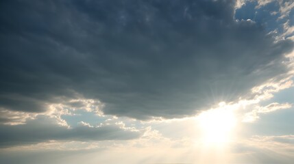 A brilliant sun shines brightly from behind dramatic storm clouds in the beautiful summer sky above.