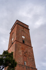 Old red brick lighthouse tower with clock, Borkum, Germany
