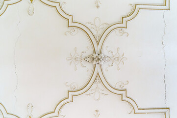 Round antique vintage decorative clay stucco relief molding with floral ornaments on white ceiling in abstract classical style interior