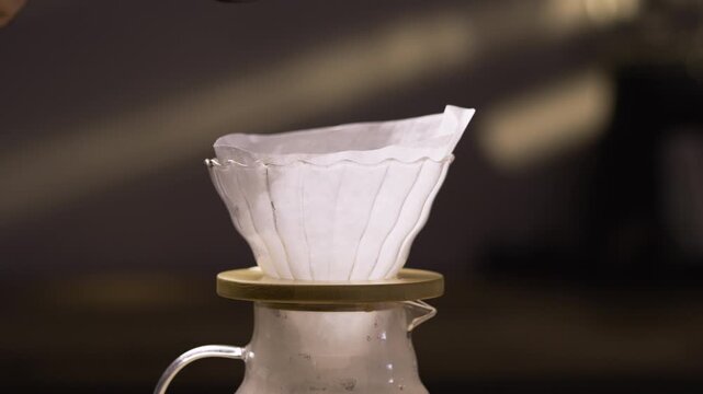 Hand drip coffee. Barista pouring brew coffee ground into filter