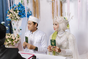 A married couple proudly showing their marriage books while smiling together. Capturing joy, commitment, and celebration of a new chapter. Ideal for wedding content, relationship themes, marital