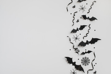 Halloween party minimal template from black festive decorations on white background top view.