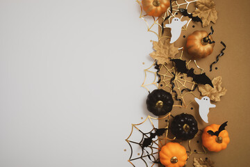 Halloween party background from orange and black pumpkins on table top view. Happy halloween holiday greeting card, flat lay.