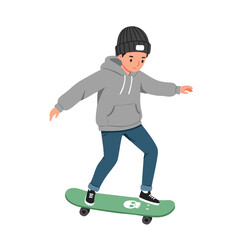 a boy wearing a beanie hat, a grey hoodie, and jeans, balancing on a green skateboard with a cute skull graphic