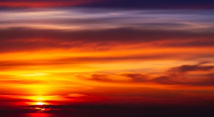 Fiery Sunset Sky with Vibrant Colors and Dramatic Clouds.