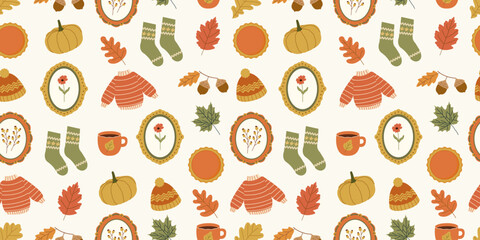 Autumn cozy seamless pattern. Cute fall season design with hand drawn pumpkins, sweaters, socks, pie, coffee mug, beanie hat, frames with flowers, acorns. Vector background for wrapping paper, fabric.