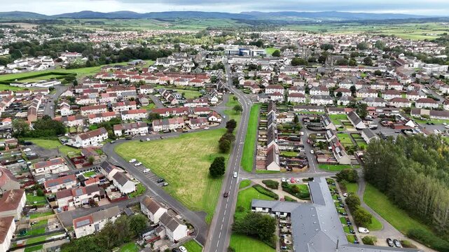 Aerial of Kilwinning town in North Ayrshire, Scotland shows suburban homes, roads, and green spaces