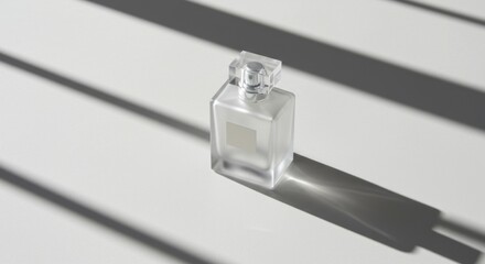 Frosted glass perfume bottle casting a shadow on a white surface with striped light