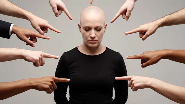 Bald woman surrounded by fingers pointing at her face