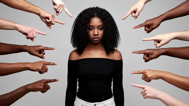 Woman surrounded by pointing fingers in studio. An evocative, powerful portrayal of harassment and shame. Social pressure, toxic environment, negative emotions.