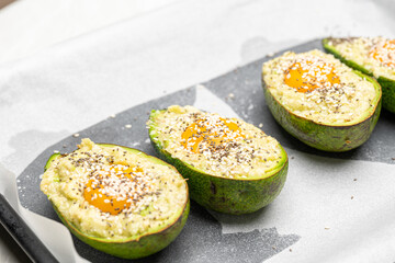 Half Avocado Stuffed with Egg and Sprinkled with Sesame for Baking