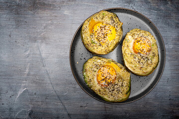 Top View of Baked Avocado with Egg and Seeds on Plate with Copy Space