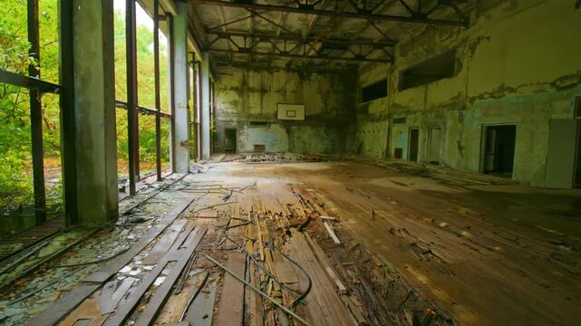 Haunting footage captures the desolate interior of the abandoned sports hall adjacent to the Azure swimming pool in Pripyat, Ukraine. Part of the Chernobyl Exclusion Zone, this structure stands as a p