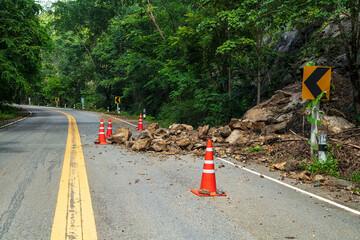 Rocks fell from the mountains onto the road, destroying the asphalt and blocking half of the roadway.