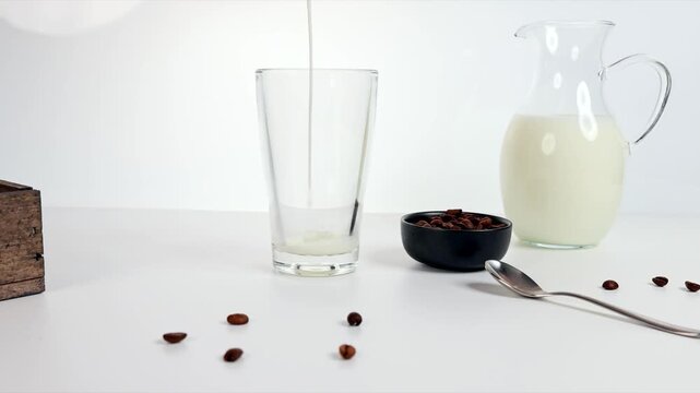 Kaffee in ein Glas mit Milch gie&szlig;en