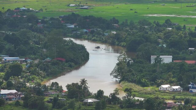 Regularly floods Padas River surrounded Bisaya-Brunei settlements, rainforest, tropical farming. View of Beaufort, Malaysia. Tropical city, heat and high humidity, monsoon season. Houses with veranda