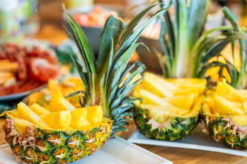 Pineapple halves filled with fresh slices served at a colorful fruit display for a summer event