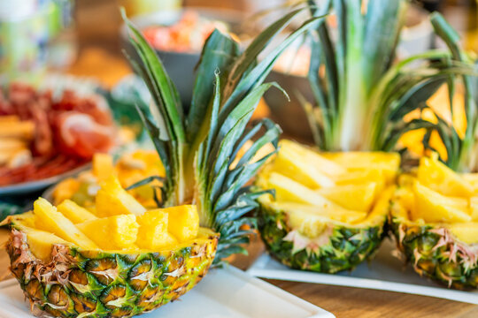 Pineapple halves filled with fresh slices served at a colorful fruit display for a summer event