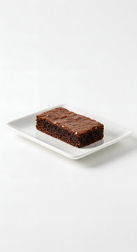 A small rectangular slice of chocolate brownies placed on a simple rectangular white plate