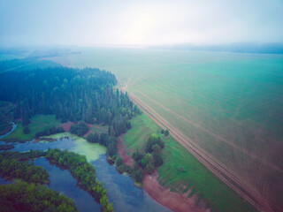 Aerial view landscape on foggy morning in countryside with lake and forest

