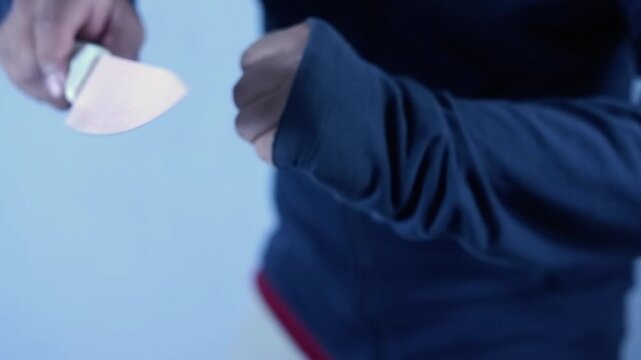 The killer holds a kitchen knife, with a dim, eerie light.