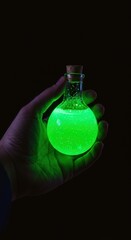 Glowing Green Potion in Glass Bottle Held in Hand