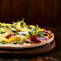 Pizza with chorizo ​​sausage, mozzarella cheese and yellow pepper. Rustic wooden background. Soft focus.	
