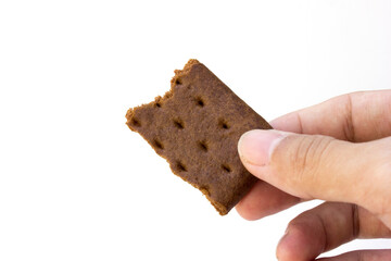 Hand holding a chocolate biscuit on a white background