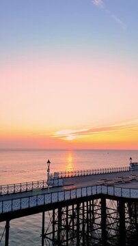 Aerial drone footage of sunrise above Penarth pier. Vertical push in shot.