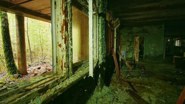 An eerie and poignant view inside a dilapidated classroom of an abandoned school in Pripyat, Ukraine, within the Chernobyl Exclusion Zone. Peeling paint, broken windows, and decaying furniture evoke t