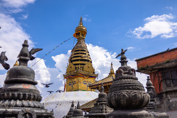 Swayambhunath Stupa with Flying Pigeons in Kathmandu, Nepal &ndash; Ancient Buddhist Shrine Framed by Stone Stupas and Dramatic Sky.