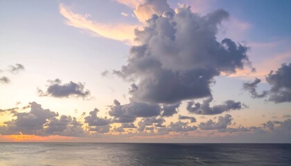 A breathtaking vista of a calm ocean under a vibrant sky ablaze with orange, yellow, and grey clouds
