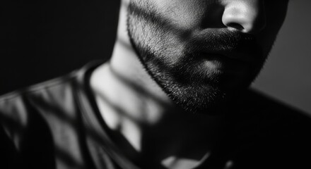 Shadowed close-up of young caucasian male with beard in dramatic lighting