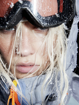Close-up of a female athlete's face in winter gear for skiing or snowboarding. Popular winter recreation and mountain sports activities.
