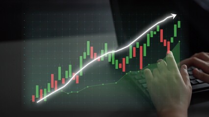 A close-up view of a person analyzing financial data on a laptop, featuring a green and red candlestick chart indicating a strong upward market trend, highlighting investment growth. Copula