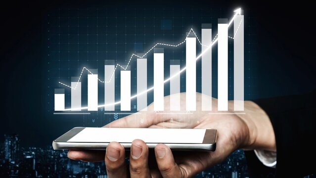 A hand holding a smartphone displays a dynamic financial graph against a dark background, representing business growth, data analysis, and technological innovation. Copula