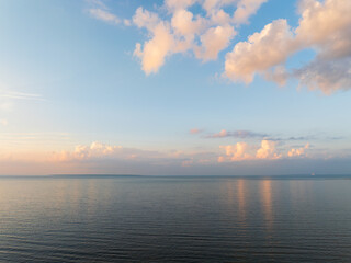 A peaceful aerial drone shot over the calm Baltic Sea in Estonia during a beautiful pastel-colored sunset or sunrise.