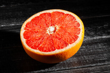 sliced grapefruit on black wood background