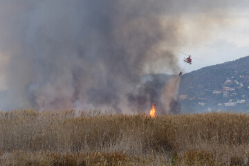 HELICOPTERO EN VUELO CON UNA CESTA DE AGUA PARA SOFOCAR UN INCENDIO