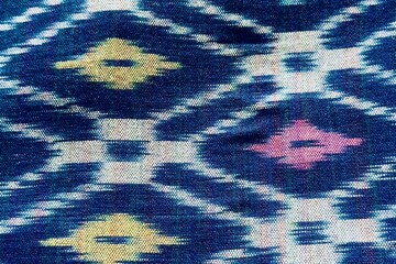 Handwoven ikat textile featuring colorful geometric patterns. Perfect for backgrounds, fashion, interior design, and cultural themes.