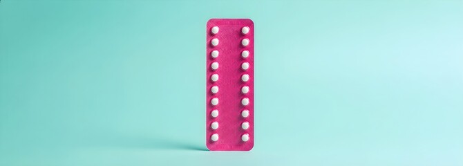 Fototapeta premium Pink blister pack with oral contraceptive pills on a blue background, symbolizing family planning and reproductive health with copy space. A month of contraception and women's choice template.