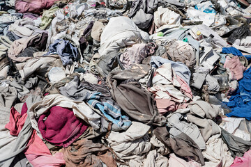 pile of used clothes in the trash