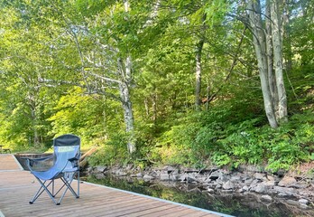 Camp chair on a dock with forest in the background