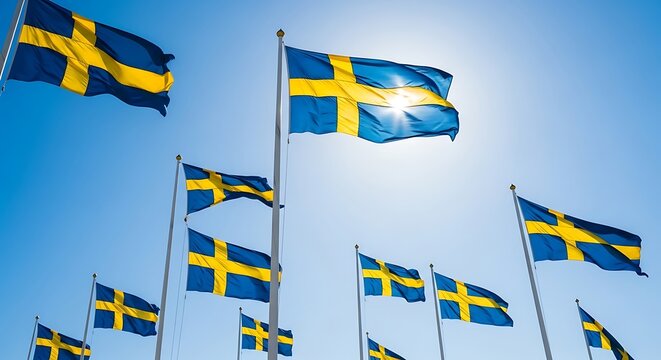 Swedish flags waving proudly against a bright blue sky, symbolizing national pride and heritage.