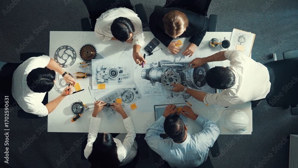 Aufkleber top view of engineer pointing at turbine engine at meeting table with equipment. aerial view of prof