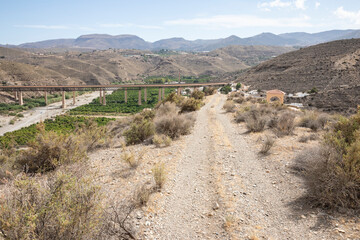 a mountain path with a view to the railway bridge in Santa Fe de Mondujar, Almeria, Andalusia, Spain