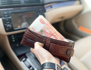 Bundles of money with a nominal value of 5 thousand Russian rubles in the hands of a man. A...