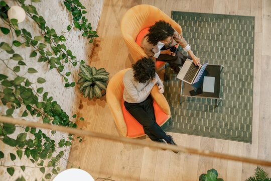 A cozy and modern workspace designed for people to collaborate comfortably in stylish chairs using laptops