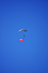 Military paratrooper waving the Chilean flag in the sky